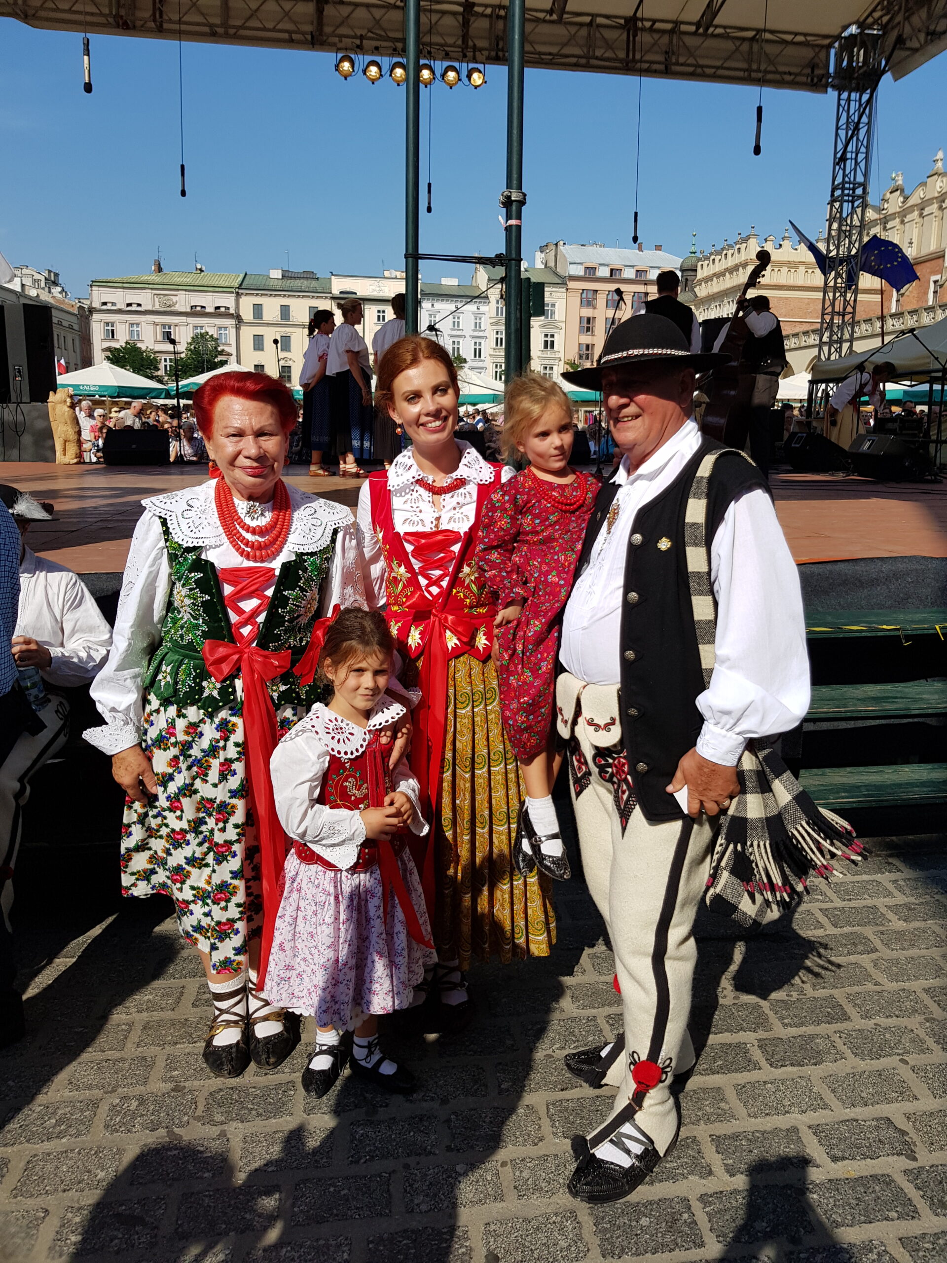 A group of performers in traditional Polish folk costumes during a lively folklore show in Kraków.