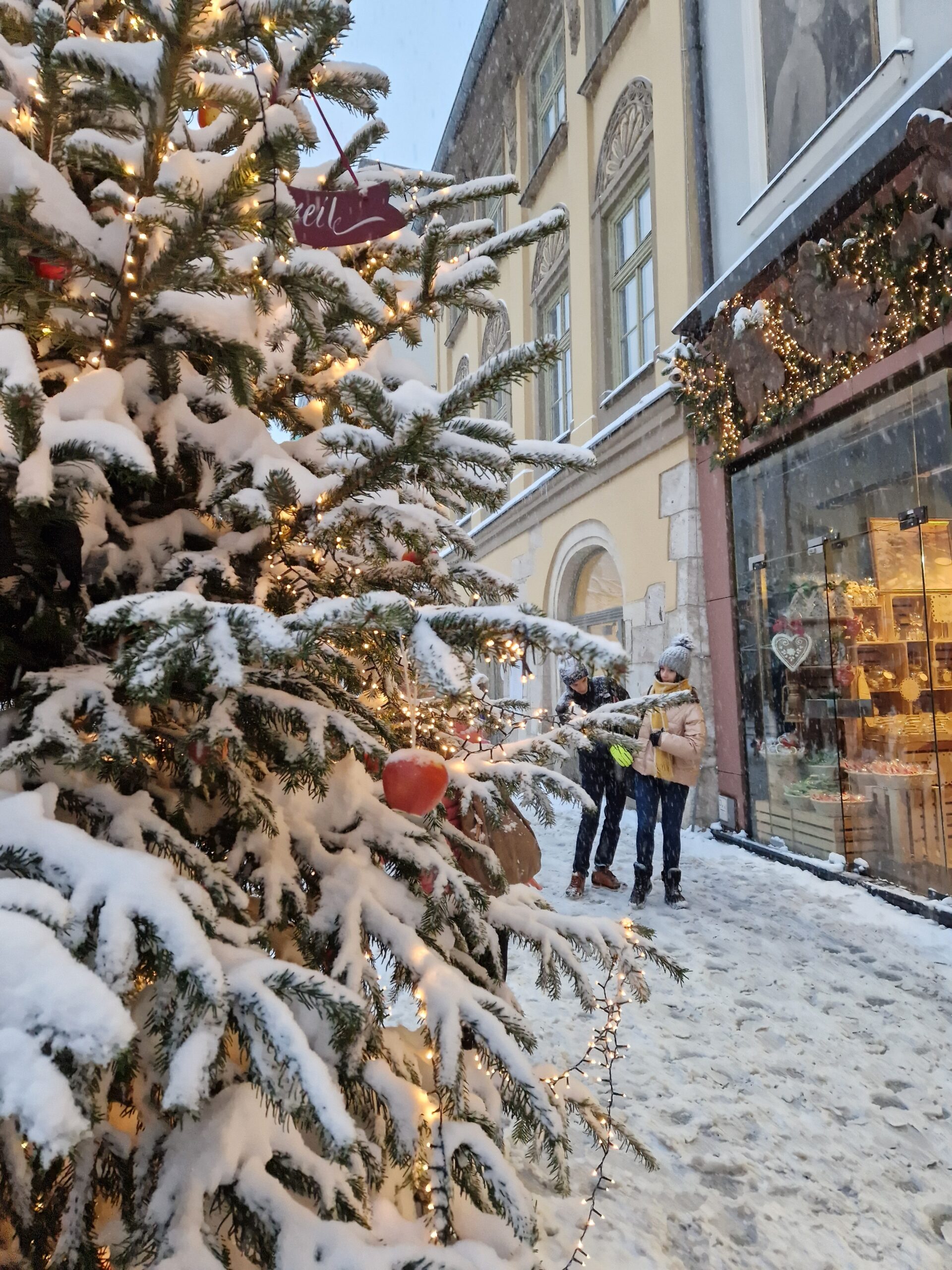 Festive Christmas scene in Kraków with holiday markets, decorated trees, and illuminated streets.